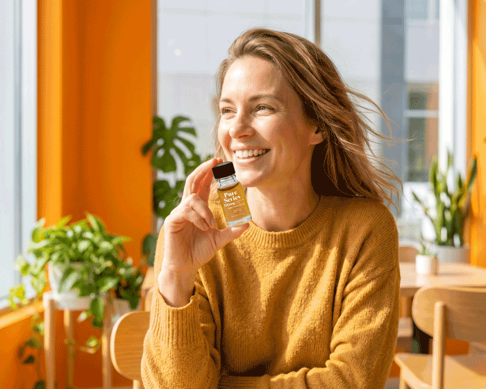a woman holding a small bottle of liquid