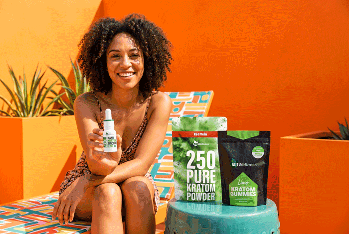 a woman sitting on a chair holding a bottle of kratom powder