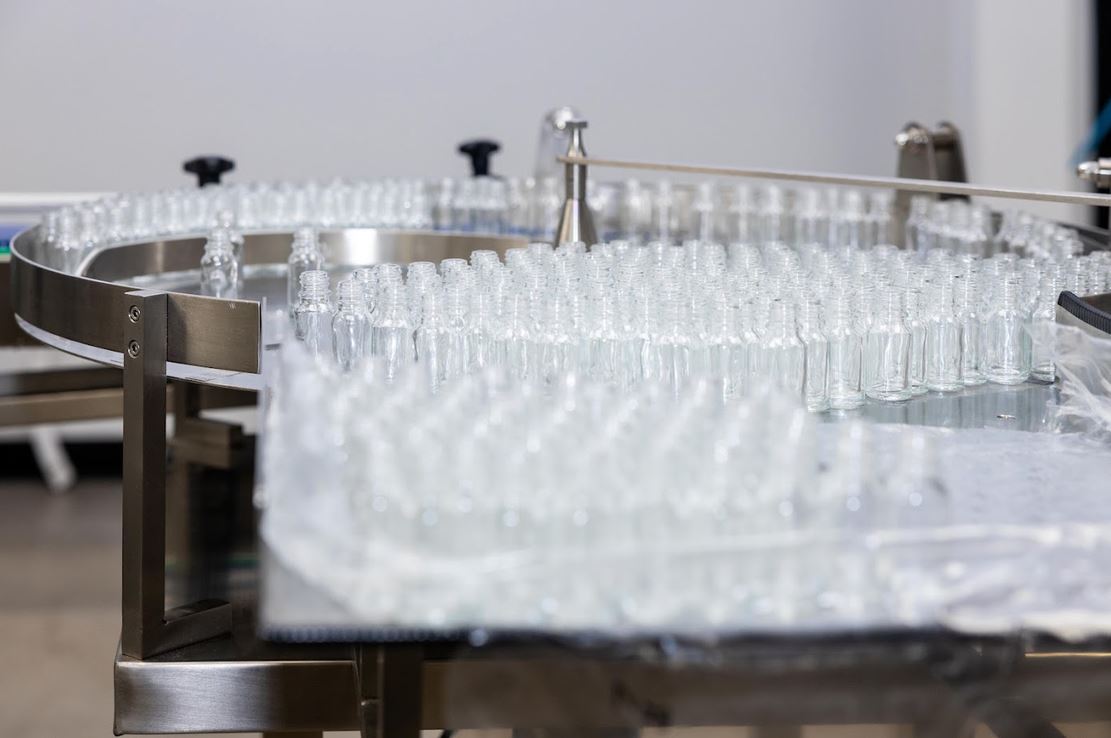 a conveyor belt with clear bottles