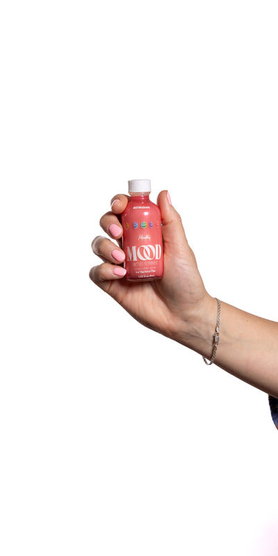 a hand holding a bottle of liquid