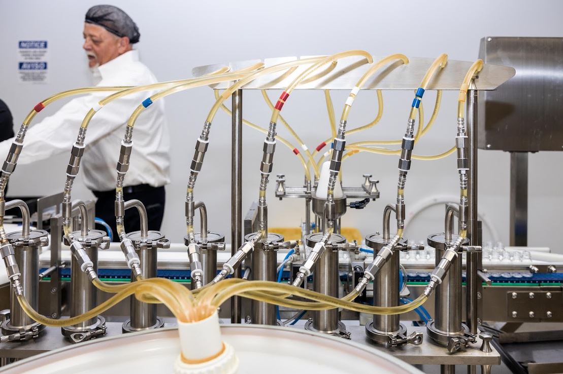 a man in a white coat and white coat standing in front of a machine